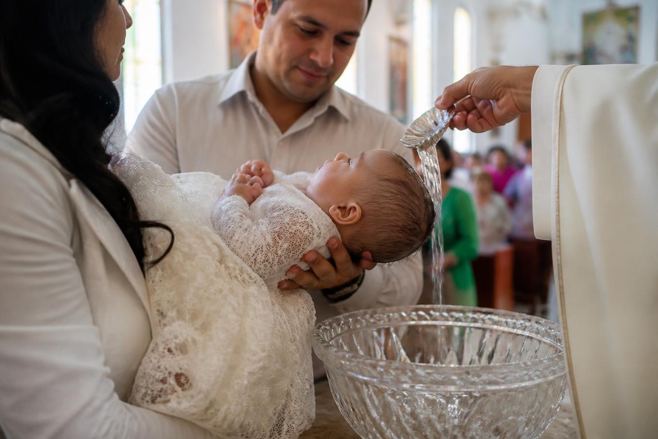Batizado em igreja com luz suave entrando pelos vitrais
